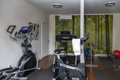 a gym with two exercise bikes in a room at Le Champlain 101- Condo avec Piscine in Bromont