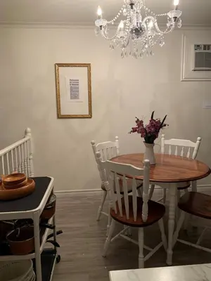 a dining room with a table and chairs and a chandelier at Le Vétérans , Au Cœur du Centre-Ville , Tout à Pied ! in Lac-Mégantic