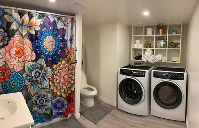a bathroom with a washing machine and a shower curtain at Le Vétérans , Au Cœur du Centre-Ville , Tout à Pied ! in Lac-Mégantic