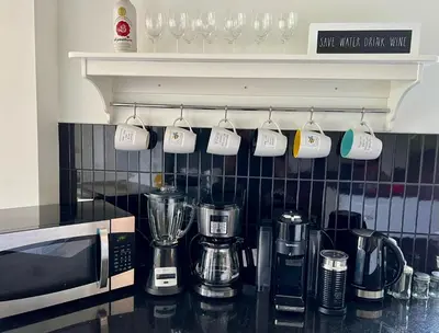 a kitchen counter with coffee mugs hanging from a wall at Newly Renovated villa with magnificent views in Coaticook