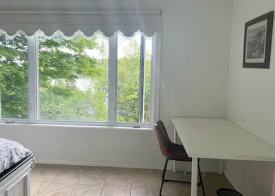 a white bedroom with a desk and a window at Newly Renovated villa with magnificent views in Coaticook