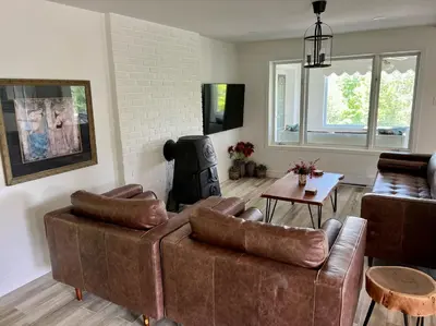a living room with a couch and a table at Newly Renovated villa with magnificent views in Coaticook