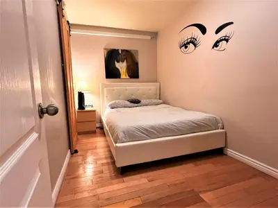 a small bedroom with a bed and two eyes on the wall at ReUnion in Montréal
