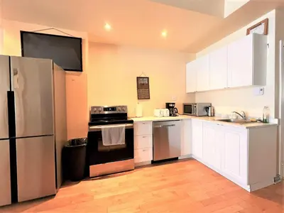 a kitchen with white cabinets and a stainless steel refrigerator at ReUnion in Montréal