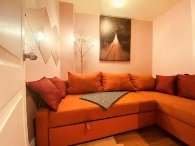 an orange couch in a room with a painting at ReUnion in Montréal