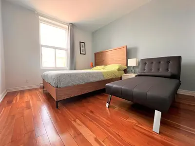 a bedroom with a bed and a bench in it at ReUnion in Montréal