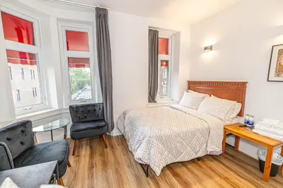 a bedroom with a bed and a desk and a chair at hotel le coach in Montréal