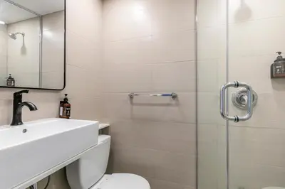 a bathroom with a shower and a sink and a toilet at hotel le coach in Montréal
