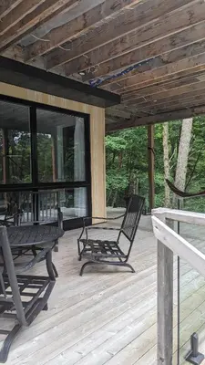a porch with two chairs and a bench on it at loft in the mountains, near Bromont in Shefford