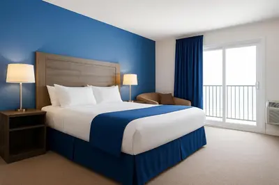 a bedroom with a large bed with a blue wall at Hotel de la Rive in Sorel
