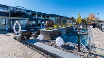 a swimming pool with a fountain in front of a building at Hotel de la Rive in Sorel