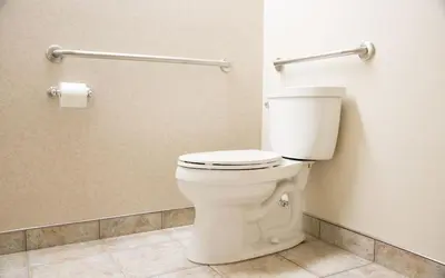 a bathroom with a white toilet in a stall at Hotel de la Rive in Sorel