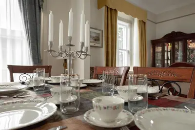 a dining room table with chandelier and plates on it at Chez l'Doc in Saint-Prosper