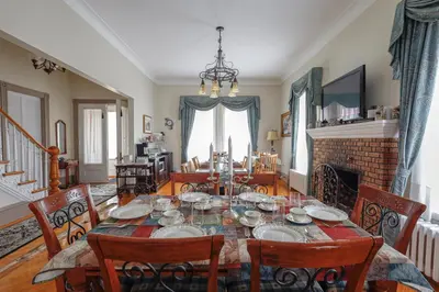 a dining room with a table and chairs and a fireplace at Chez l'Doc in Saint-Prosper