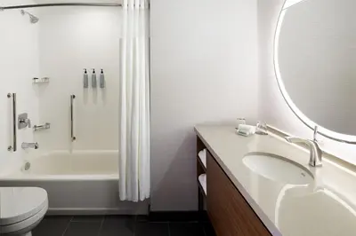 a bathroom with a sink and a tub and a toilet at Courtyard Montreal Midtown in Montréal