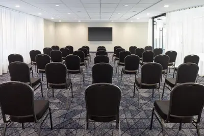an empty room with chairs and a projection screen at Courtyard Montreal Midtown in Montréal