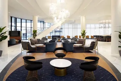 a lobby with a waiting room with chairs and tables at Courtyard Montreal Midtown in Montréal