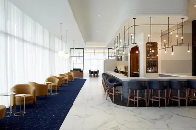 a lobby with a bar with chairs and a counter at Courtyard Montreal Midtown in Montréal