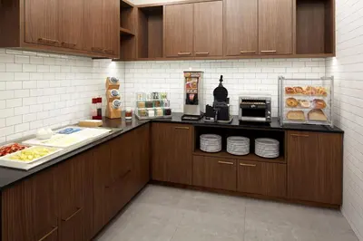 a kitchen with wooden cabinets and aasteryasteryasteryasteryasteryasteryasteryasteryastery at Residence Inn Montreal Midtown in Montréal