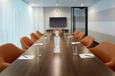 a conference room with a long table and orange chairs at Residence Inn Montreal Midtown in Montréal