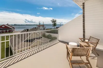 a balcony with two chairs and a view of the water at Hôtel le Rosay in Venise-en-Québec