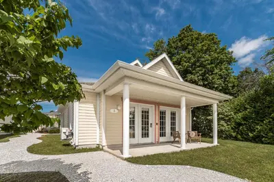 a small white house with a porch at Hôtel le Rosay in Venise-en-Québec