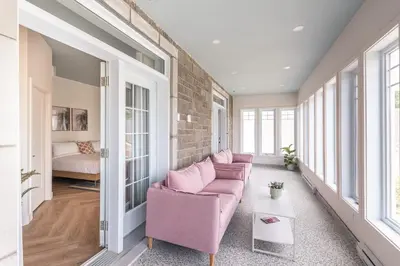 a living room with a pink couch and a brick wall at Hôtel le Rosay in Venise-en-Québec