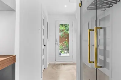 a hallway with white walls and a door with yellow handles at Le Sainte-Marie - Vieux-Terrebonne in Terrebonne