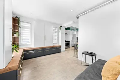 a kitchen and living room with white walls at Le Sainte-Marie - Vieux-Terrebonne in Terrebonne