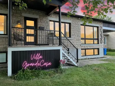 a house with a sign in front of it at Villa luxueuse avec vue sur le fleuve Villa GrandeCasa in Trois-Rivières