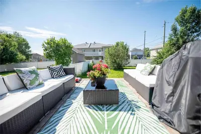 a patio with couches and a table with flowers on it at Villa luxueuse avec vue sur le fleuve Villa GrandeCasa in Trois-Rivières
