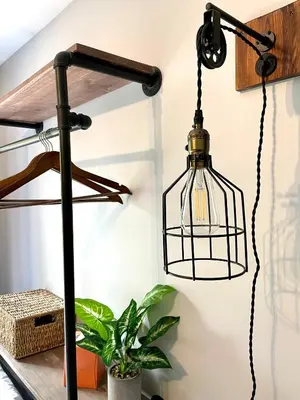 a black lantern hanging from a wall next to a plant at Grand Central Hotel Richmond in Richmond