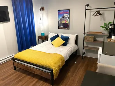 a bedroom with a bed with a yellow blanket and blue curtains at Grand Central Hotel Richmond in Richmond