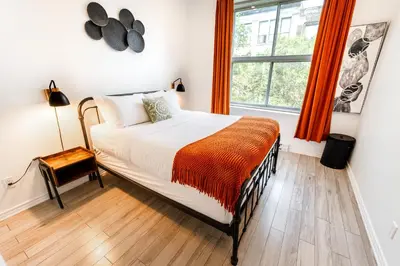 a bedroom with a bed and a window with orange curtains at AFRICA - SelfCheckIn - Plateau - St-Laurent in Montréal