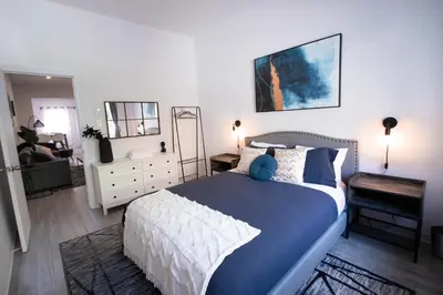 a bedroom with a blue and white bed and a living room at BLUE&GOLD - SelfCheckIn - Plateau - St-Laurent in Montréal