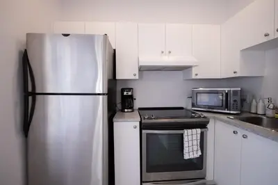 a kitchen with a stainless steel refrigerator and a microwave at BLUE&GOLD - SelfCheckIn - Plateau - St-Laurent in Montréal
