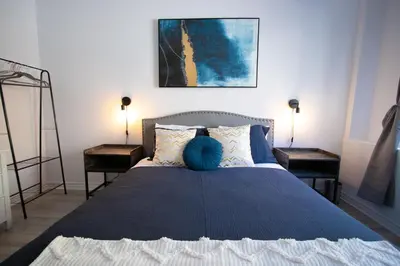 a bedroom with a blue bed with two night stands at BLUE&GOLD - SelfCheckIn - Plateau - St-Laurent in Montréal