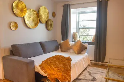 a living room with a bed with a couch and mirrors at GATSBY - SelfCheckIn - Rooftop - Terraces - St-Denis in Montréal