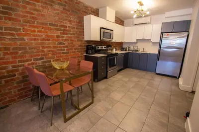 a kitchen with a table and a brick wall at GATSBY - SelfCheckIn - Rooftop - Terraces - St-Denis in Montréal