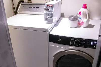 a washer and dryer with a bottle of detergent at GATSBY - SelfCheckIn - Rooftop - Terraces - St-Denis in Montréal