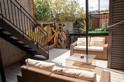 a patio with two chairs and a table and a mural at GATSBY - SelfCheckIn - Rooftop - Terraces - St-Denis in Montréal