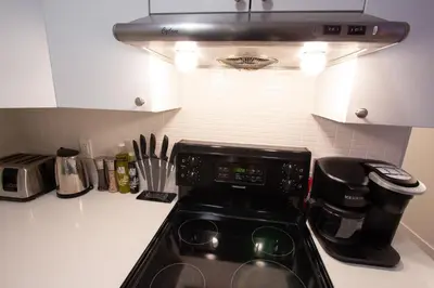 a kitchen counter with a stove and a microwave at POP - SelfCheckIn - Rooftop - Terraces - St-Denis in Montréal