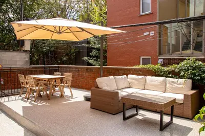 a patio with a couch and a table and an umbrella at POP - SelfCheckIn - Rooftop - Terraces - St-Denis in Montréal