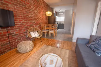 a living room with a couch and a brick wall at ZEN - SelfCheckIn - Rooftop - Terraces - St-Denis in Montréal