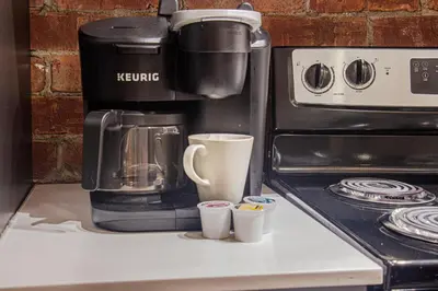 a coffee maker and cups sitting on a counter at ZEN - SelfCheckIn - Rooftop - Terraces - St-Denis in Montréal