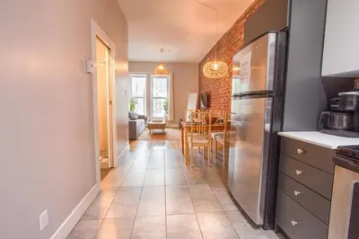 a kitchen with a refrigerator and a dining room at ZEN - SelfCheckIn - Rooftop - Terraces - St-Denis in Montréal