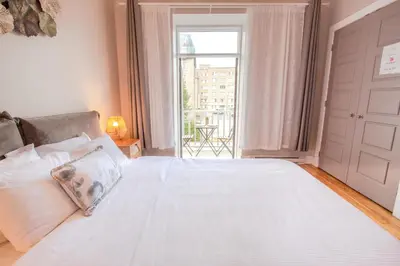 a bedroom with a large white bed with a window at ZEN - SelfCheckIn - Rooftop - Terraces - St-Denis in Montréal