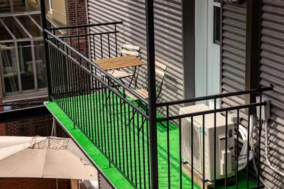 a balcony with a wooden bench on the side of a house at FICTION - SelfCheckIn - Rooftop - Terraces - St-Denis in Montréal