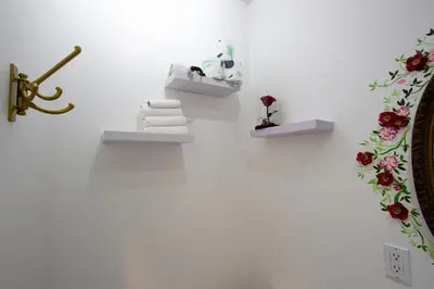 a white wall with two shelves with towels and a mirror at FICTION - SelfCheckIn - Rooftop - Terraces - St-Denis in Montréal