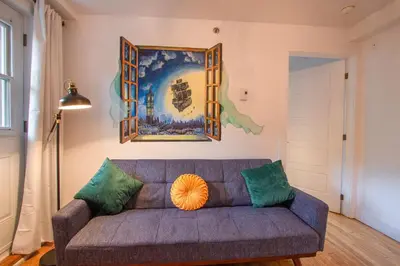 a living room with a couch and a painting on the wall at FICTION - SelfCheckIn - Rooftop - Terraces - St-Denis in Montréal
